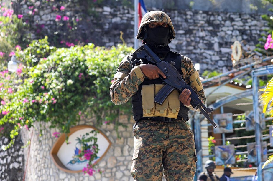 Militaire haïtien en tenue de camouflage tenant une arme