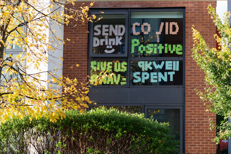 Protest messages are written in post-it notes on dorm windows
