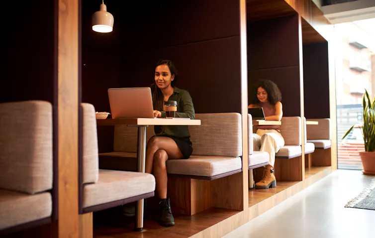people working in office with breakout spaces.