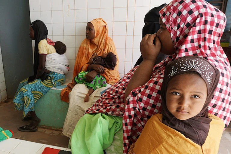 Women sit in a room, each with a baby