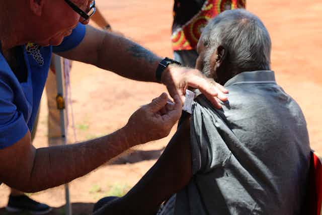 A senior Aboriginal man is being vaccinated against COVID-19.