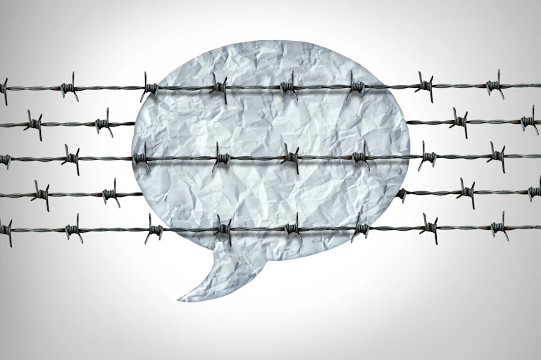A speech bubble overlaid with barbed wire