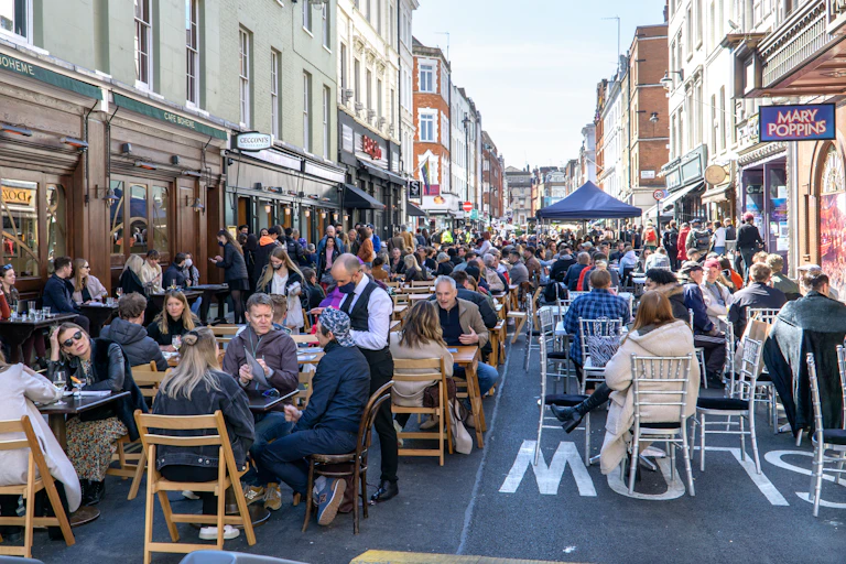 People in groups dining outside in central London