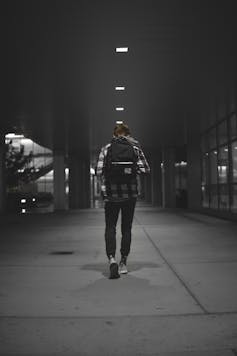 A student with backpack seen from behind.