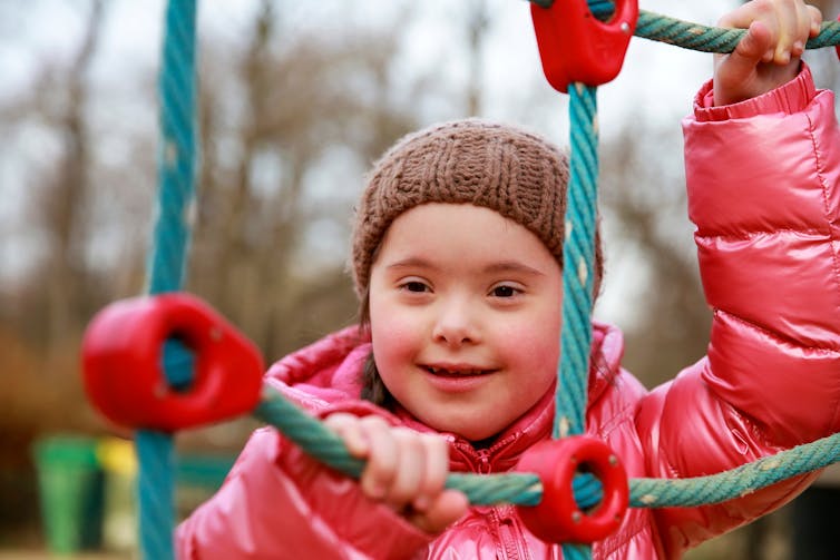 A girl smiling in the playground.