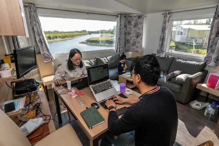 Un couple télétravaille depuis un bungalow de camping à l'Ile de Ré, pendant que leur fille joue à proximité, le 16 avril 2021.