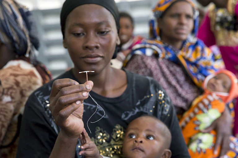 A woman holding an IUD.