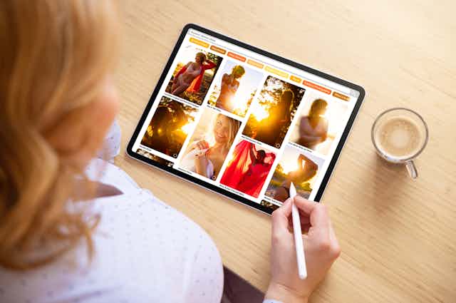 A woman looking through a pinterest board of beautiful images of women on an ipad