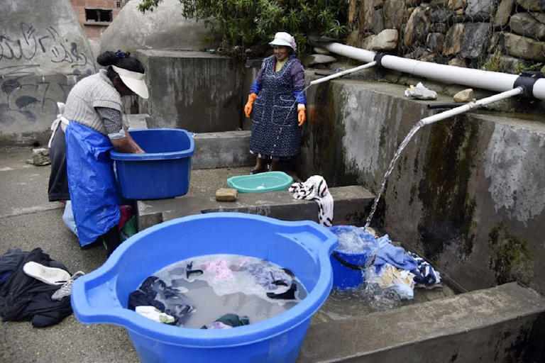 Dos mujeres de los pueblos indígenas de Bolivia lavan su ropa en un lavadero municipal con agua de lluvia en La Paz, el 12 de septiembre de 2019.