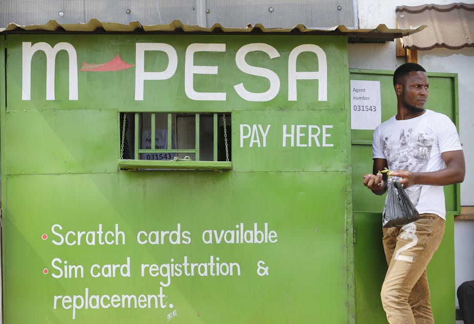 A man stands next to an M-Pesa service outlet in Nairobi, Kenya.
