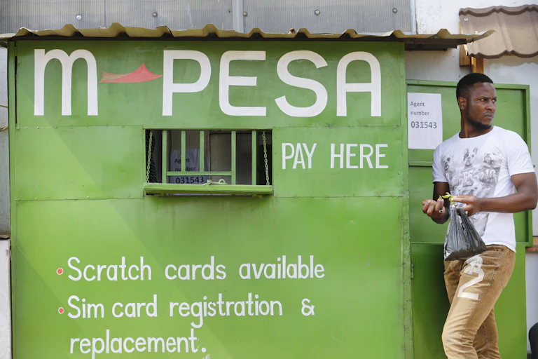 A man stands next to an M-Pesa service outlet in Nairobi, Kenya.