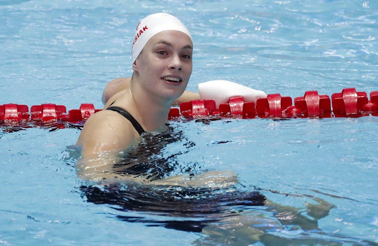 Swimmer in swim cap treading water and holding onto swim rope