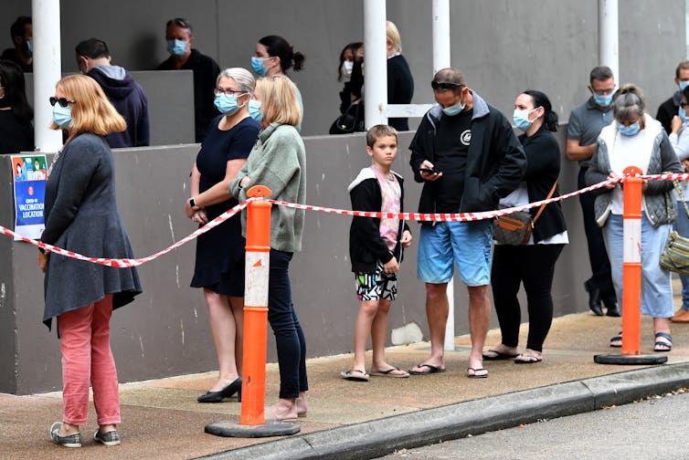 Personas haciendo cola para recibir una vacuna COVID en Queensland.