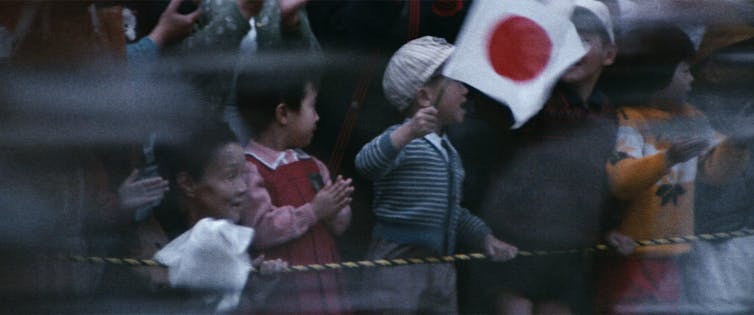 A young boy waves the Japanese flag