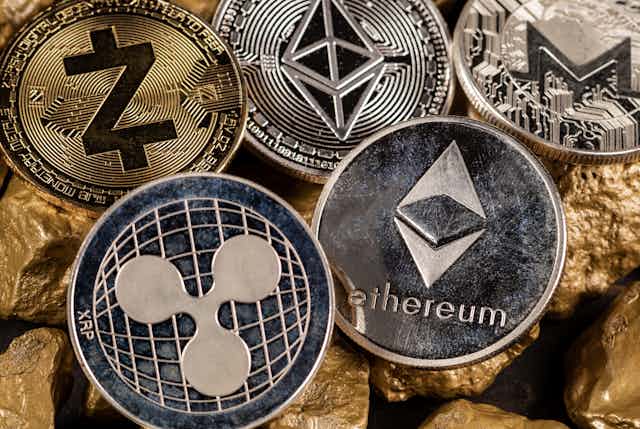 Metal coins featuring the logos of altcoins