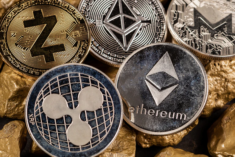 Metal coins featuring the logos of altcoins