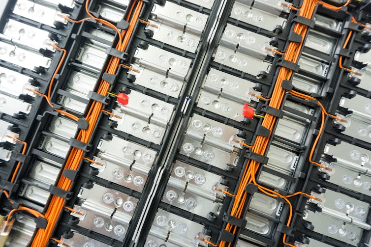Silver cartridges linked by orange and black cables.