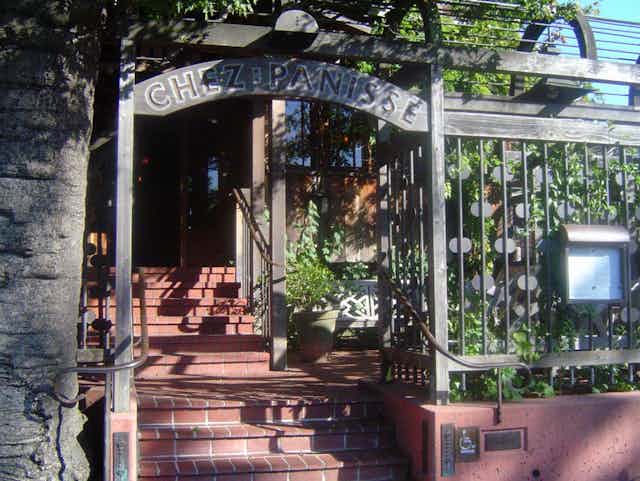 Steps ascend to restaurant entrance under an arch .