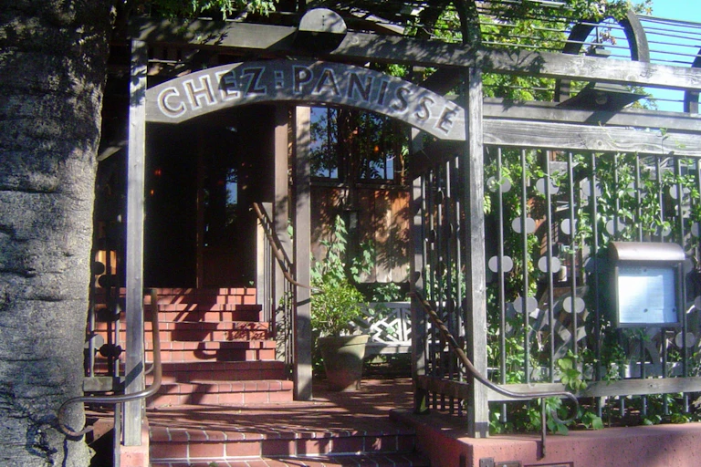 Steps ascend to restaurant entrance under an arch .