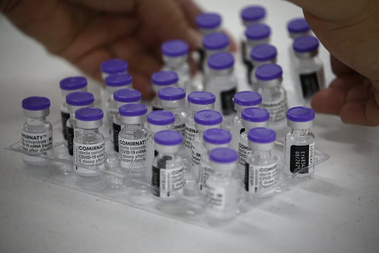 Vials of the Pfizer vaccine being prepared for delivery