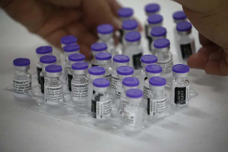 Vials of the Pfizer vaccine being prepared for delivery