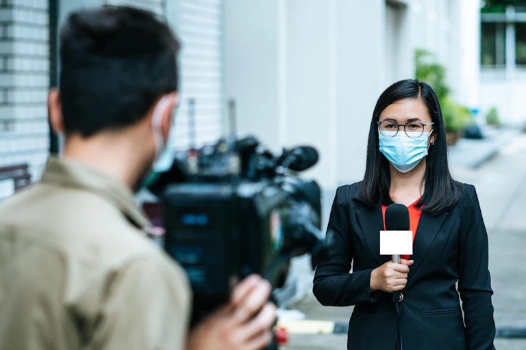 Journalist and cameraman shooting outdoor news update while wearing mask prevent Covid-19 or coronavirus quarantine pandemic.