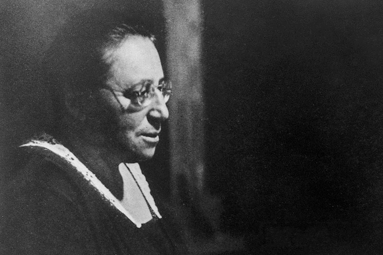 A black and white portrait of a middle-aged woman.