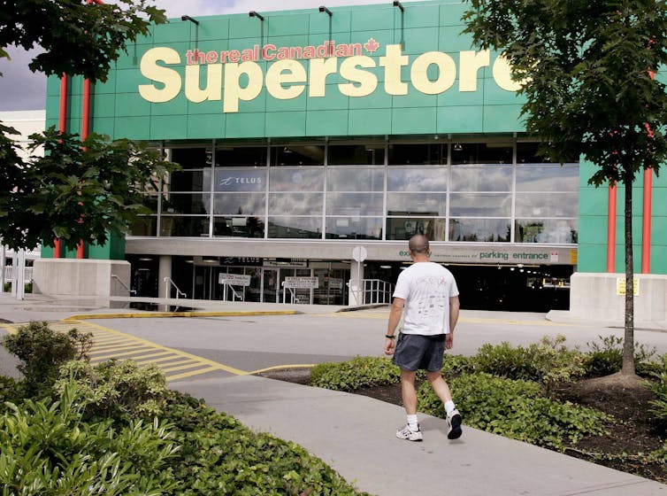 A man walks to The Real Canadian Superstore in Coquitlam, B.C.
