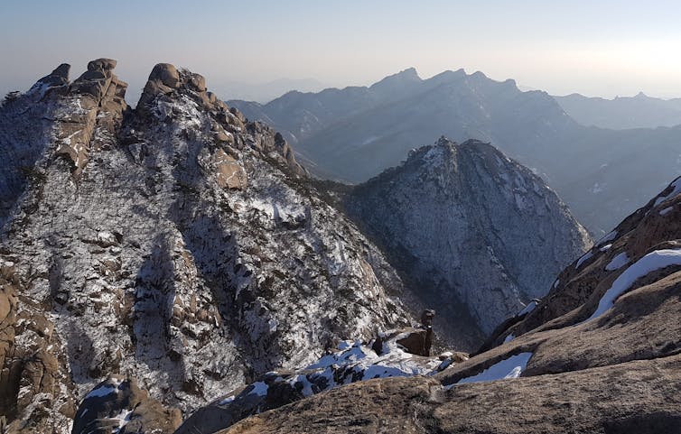 A rocky mountain vista with streaks of snow.
