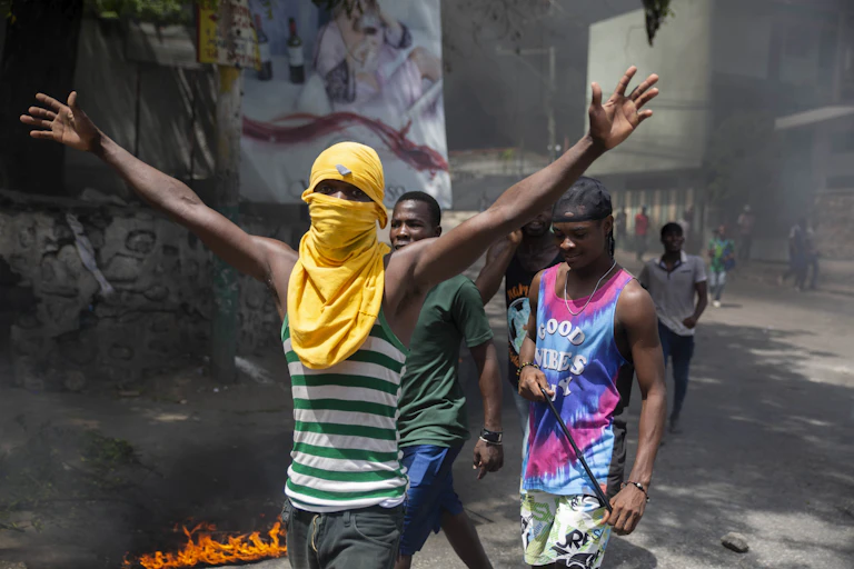 Young men demonstrating in a street, one of them wearing a mask