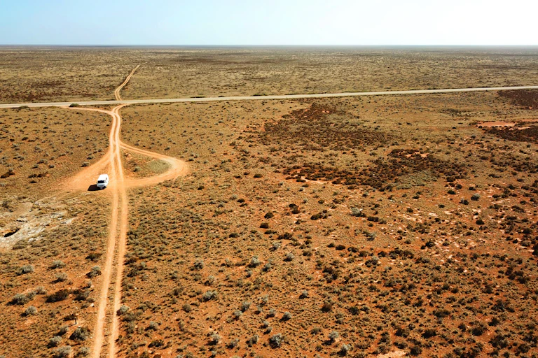 A car on a dirt road in the desert