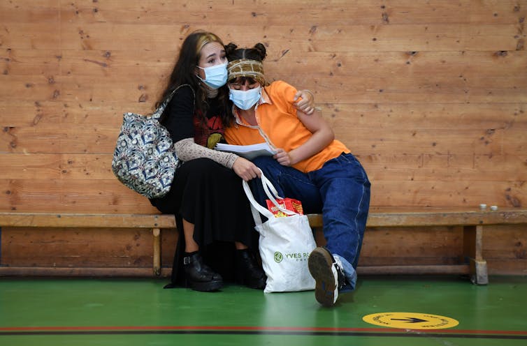 Two young people wearing masks.