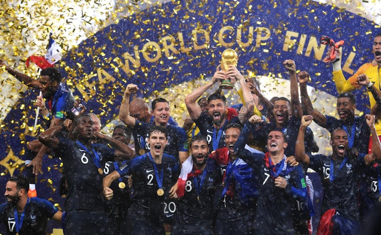 The French football team celebrating in a cloud of confetti.