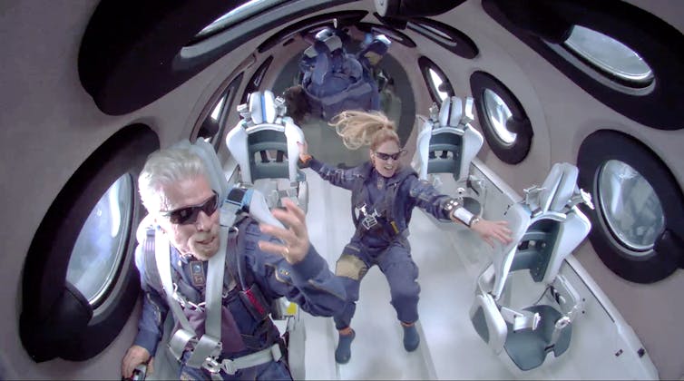 Two people in space suits attain zero gravity.