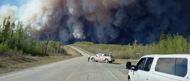A dense cloud of wildfire smoke seen from the evacuation route during the Beatton airport road fire.