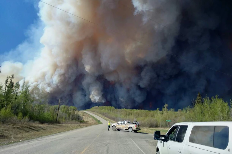 A dense cloud of wildfire smoke seen from the evacuation route during the Beatton airport road fire.