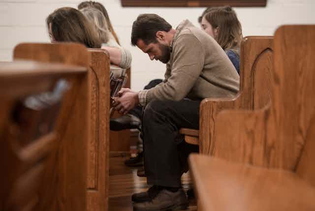 People bow their heads in prayer during a Sunday evening service at Grace Orthodox Presbyterian Church in Lynchburg, Virginia.