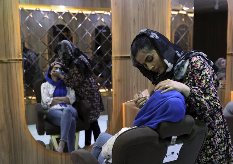 A woman applies makeup on a customer at a beauty Salon in Kabul, Afghanistan.