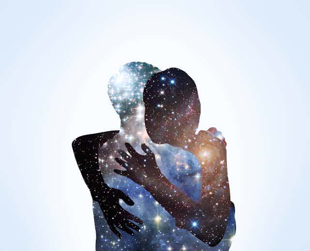 Two people hugging. Each one looks like they are made of stars in the night sky.