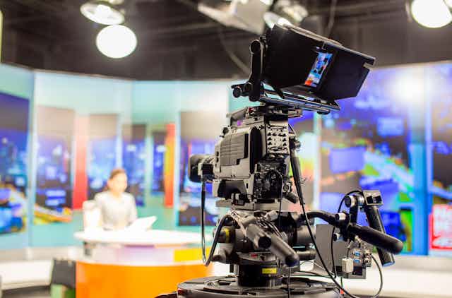 TV studio with camera and woman news presenter