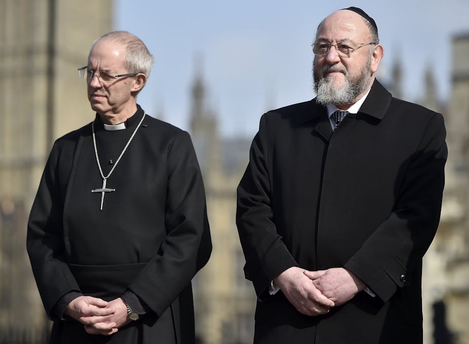 Britain's Archbishop of Canterbury Justin Welby (L) and Chief Rabbi of the United Hebrew Congregations of the Commonwealth Ephraim Mirvis (R) attend a vigil in the grounds of Westminster Abbey