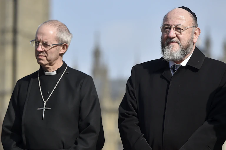 Britain's Archbishop of Canterbury Justin Welby (L) and Chief Rabbi of the United Hebrew Congregations of the Commonwealth Ephraim Mirvis (R) attend a vigil in the grounds of Westminster Abbey
