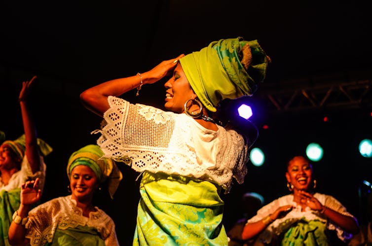 A person dances in green and white clothes
