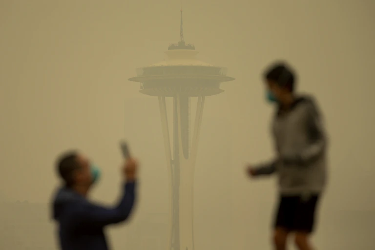 A man and boy outside the Seattle Space Needle shrouded in smoke