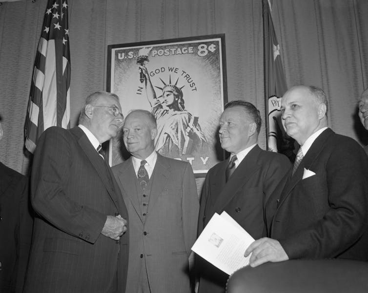 President Eisenhower at a ceremony introducing a 8-cent Statue of Liberty stamp with the inscription ‘In God We Trust.'