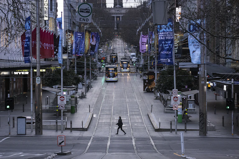 Empty streets of Melbourne CBD with one pedestrian and trams in the distance