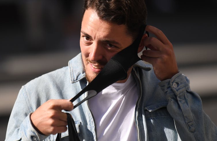 A man putting on a face mask