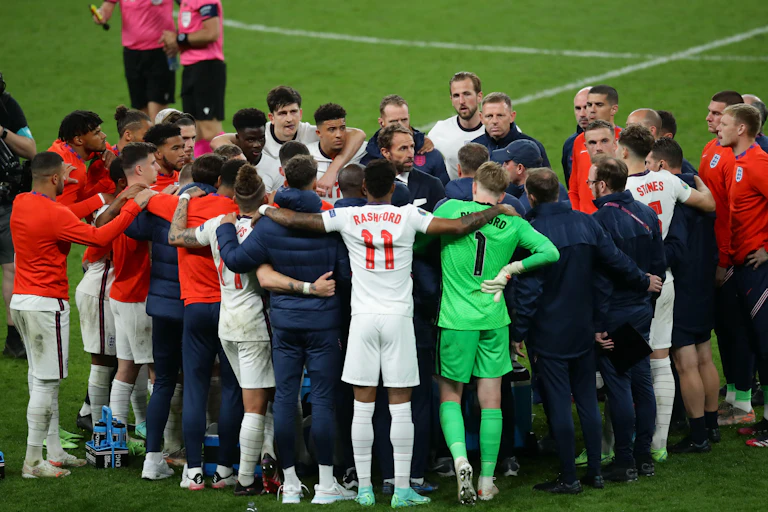 The whole England teams huddles.