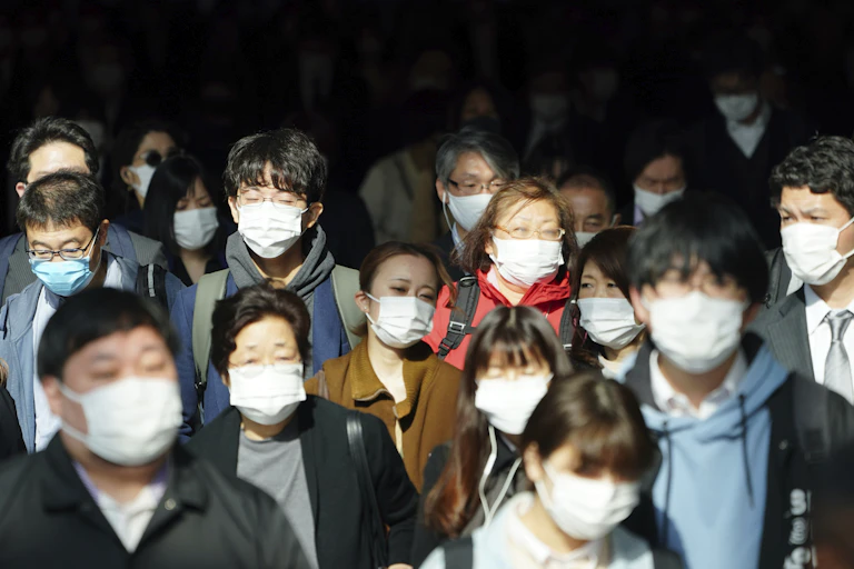 Crowd of people wearing medical face masks.