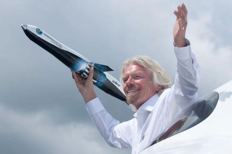 Richard Branson clutching a model Virgin Galactic spaceplane.